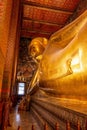 Vertical shot of the golden reclining Buddha at the Wat Pho temple in Bangkok Royalty Free Stock Photo