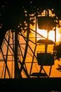 Vertical shot of the golden sunset over the silhouette of the Ferris wheel in the park