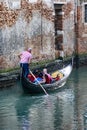 Vertical shot of a gondolier navigating on the canal in Venice, Italy