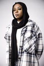 Vertical shot of a gorgeous young African woman wearing a checkered shirt and a black hijab Royalty Free Stock Photo