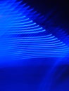 Vertical shot of gradual rhythmic light trails on a blue background