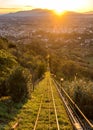 Vertical shot of grass covered pathway over a city in a valley with the sun shining in background Royalty Free Stock Photo