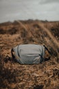 Vertical shot of a gray Peak design 5L sling bag on a grass