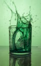 Vertical shot of a green cocktail splash on a green background Royalty Free Stock Photo