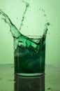 Vertical shot of a green cocktail splash on a green background Royalty Free Stock Photo