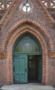 Vertical shot of a green door on a brick building Royalty Free Stock Photo