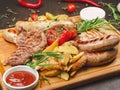 Grilled meat platter with pork and chicken steak, sausages and peasant potatoes with two sauces Royalty Free Stock Photo