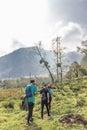 vertical shot of a group of hikers with their backpacks in the middle of the tropical cloud forest on a cloudy day on the slopes