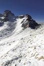 Vertical shot of a group of mountaineers walking through a landscape full of snow and rocks on a morning in the mountains of