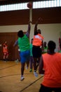 Vertical shot of a group of young people playing basketball in an indoor court in Kleve, Germany