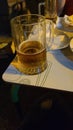Vertical shot of a half-empty glass of beer on the table Royalty Free Stock Photo