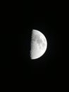 Vertical shot of a half moon against a dark night sky Royalty Free Stock Photo