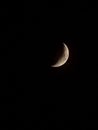 Vertical shot of a half moon illuminating the dark night sky Royalty Free Stock Photo