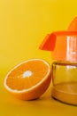 Vertical shot of a half orange with a squeezer isolated on a yellow background Royalty Free Stock Photo