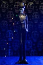 Vertical shot of a Halloween figurine against a grungy skull wall with blue lights background