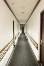 Vertical shot of the hallway of a building with white walls under the lights