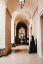 Vertical shot of a hallway with white walls and old chandeliers on the ceiling Royalty Free Stock Photo