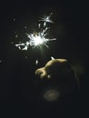 Vertical shot of a hand holding a sparkler on black background Royalty Free Stock Photo