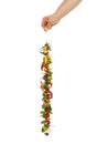 Vertical shot of a hand holding a string of dried chili peppers isolated on white background