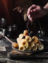 Vertical shot of a hand pouring out jam on rolled up crepes on a plate