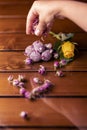 Vertical shot of a hand pouring small flowers on a romantic date table with gourmet chocolate balls