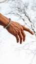 Vertical shot of a hand wearing bracelet and pointing in one direction