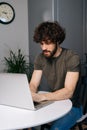 Vertical shot of handsome bearded young business man using typing laptop keyboard, writing email or message sitting at Royalty Free Stock Photo