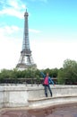 Vertical shot of a happy male posing for the camera near the Eiffel Tower in Paris, France