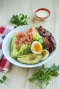 Vertical shot of the healthy ingredients on the plate with a fork and knife on a wooden table Royalty Free Stock Photo