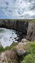 Vertical shot of high cliffs and a rocky coast in Morro Da Guarita, Torres, Brazil