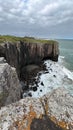 Vertical shot of high cliffs and a sea under the clouded sky in Morro Da Guarita, Torres, Brazil