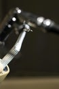 Vertical shot of a high-speed handpiece on a stand in a dental clinic with a blurry background