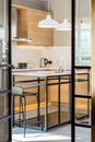 Vertical shot of a high table with bar chairs in the kitchen of a modern apartment