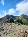 Vertical shot of a hiker looking at the rocky mountains in Snowdonia in sunny weather Royalty Free Stock Photo