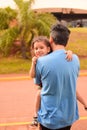 Vertical shot of Hispanic father hugging his daughter on the street Royalty Free Stock Photo