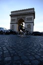 Vertical shot of the historic Arc de Triomphe with a nearby cyclist in Paris, France