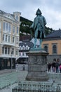 Vertical shot of a historic sculpture and nearby buildings in Bergen, Norway