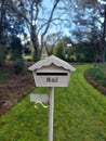Vertical shot of a home letterbox by a garden