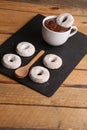 Vertical shot of homemade bagels, a cup of hot chocolate, and a wooden spoon Royalty Free Stock Photo