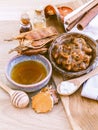 Vertical shot of honey in a bowl with cinnamon rolls and dry herbal fruits on the side