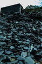 Vertical shot of a huge pile of broken rock fragments with a stone structure on top