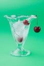 Vertical shot of ice-cream glass cup with ice and cherries. Royalty Free Stock Photo
