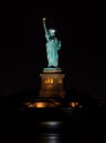 Vertical shot of the iconic Statue of Liberty and a full moon at night