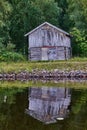 Vertical shot of an idyllic boathouse situated on the shore of Kemijoki in Lapland, Finland