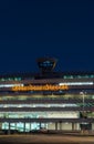 Vertical shot of the illuminated Cologne Bonn Airport sign with the air traffic tower at night