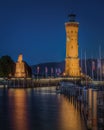 Vertical shot of the illuminated lighthouse and Bavarian Lion sculpture in Lindau, Bavaria, Germany