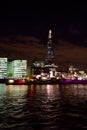 Vertical shot of the illuminated London skyline across the water Royalty Free Stock Photo