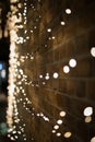 Vertical shot of illuminated string lights covering the wall of a building at night