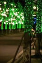 Vertical shot of illuminated tree trunks of the Impression Water street in Meishan city, China