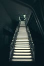 Vertical shot of industrial modern grey stone stairs illuminated with lights leading up Royalty Free Stock Photo